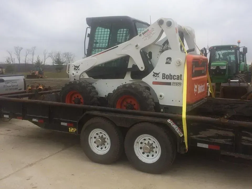5 Points Landscaping Bobcat skid-steer loaded on a trailer, ready for hire